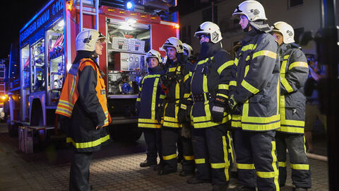 Feuerwehrleute besprechen sich beim Einsatz Feuerwehrleute besprechen sich beim Einsatz