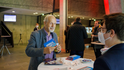 Älterer Herr an einem Infostand Älterer Herr an einem Infostand