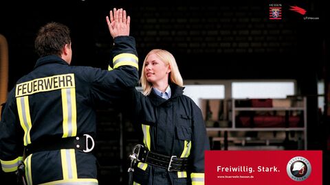Feuerwehrleute mit Aufdruck "Freiwillig. Stark. www.feuerwehr.hessen.de"